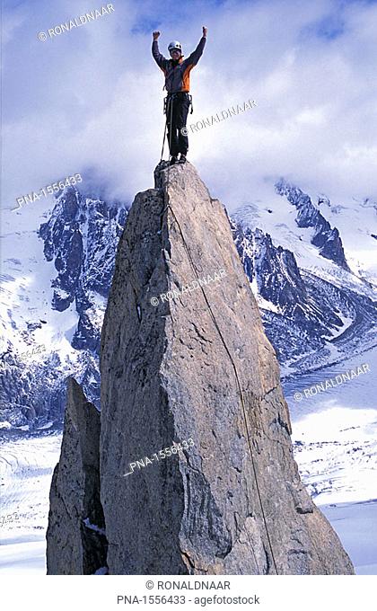 Man at the top of a rock pinnacle near Grand Montets, Chamonix, France