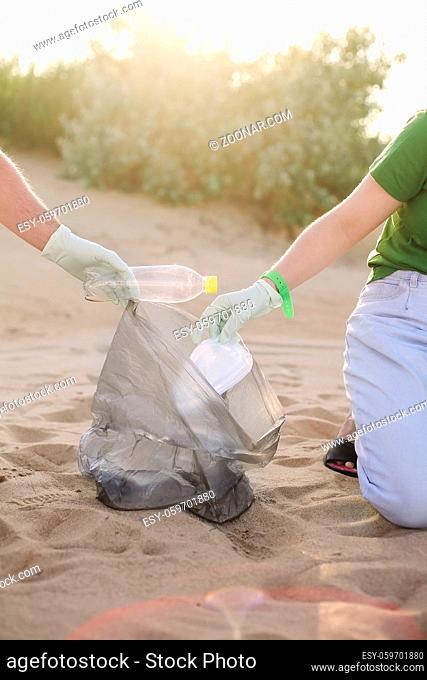 Volunteers collect trash, plastic garbage bottles and mask on the beach. Ecology, environment, pollution and ecological problems concept