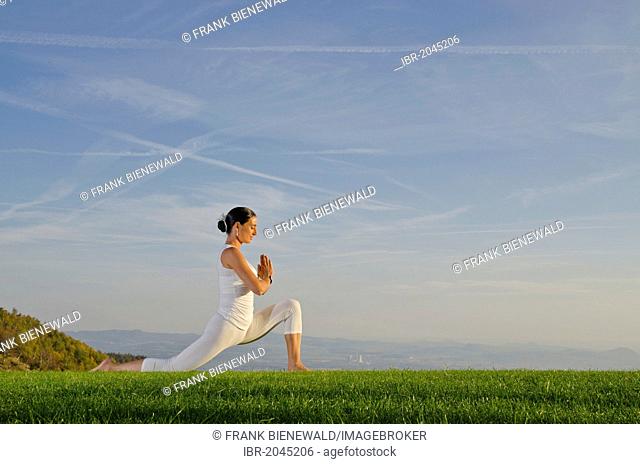 Young woman practising Hatha yoga outdoors, showing the pose anjaneyasana, chandrasana, half moon pose, Nove Mesto, Okres Teplice, Czech Republic, Europe