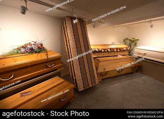 PRODUCTION - 06 June 2023, North Rhine-Westphalia, Dortmund: Various coffins can be seen. Oiled coffins, plastic-free suits and eco-urns made of charcoal are in...