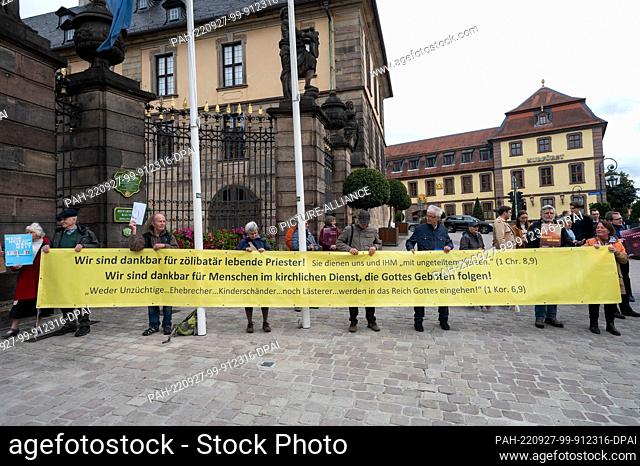 26 September 2022, Hessen, Fulda: Activists of the conservative Catholic initiative Maria 1.0 hold up a banner in front of the city palace of Fulda at the...