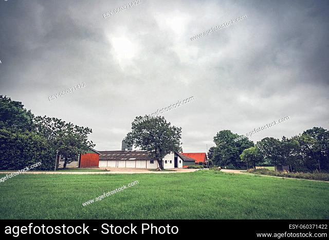 Rural landscape with a farm under a dramatic cloudy sky waiting for the rain