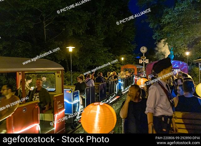 05 August 2022, Brandenburg, Cottbus: Two trains meet at a station during the so-called light rides of the Cottbus park railroad