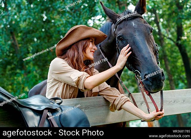 Outdoor young woman touch steed