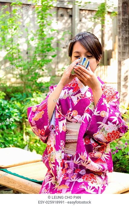 Woman with kimono dress and drink of the tea in tea house