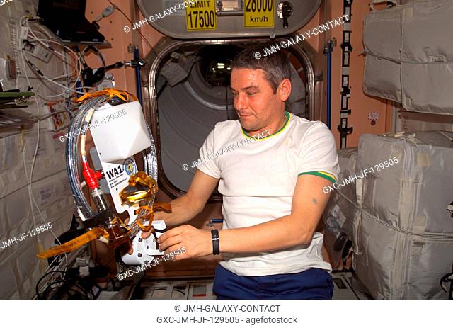 Cosmonaut Valery G. Korzun, Expedition Five mission commander, holds one of the two amateur radio antennas in the Unity node on the International Space Station...