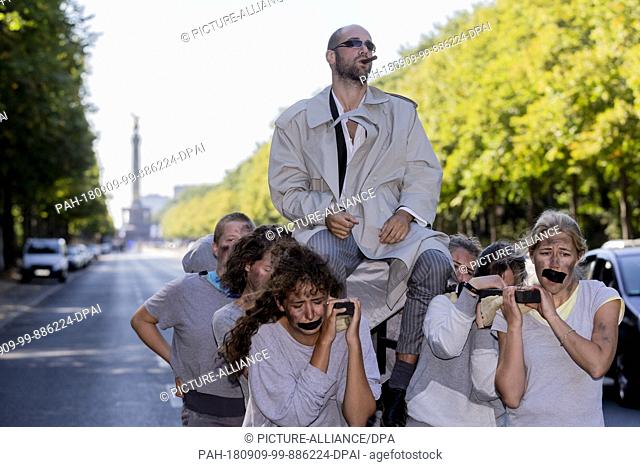 09 September 2018, Germany, Berlin: A man is carried on a sedan chair during the demonstration with art performance ""Uprising of Youth""