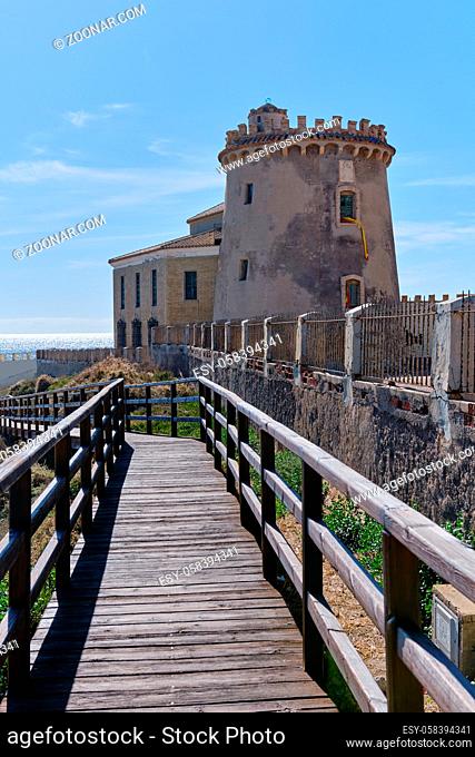 Fenced wooden bridge leading to watchtower in the Pilar de la Horadada located in the coast of Mediterranean Sea, spanish town in Province of Alicante