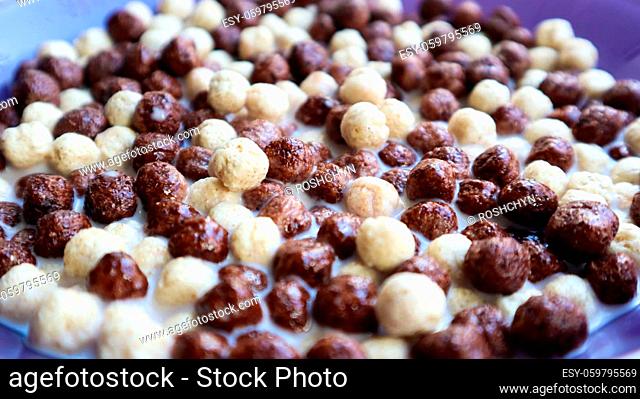 Healthy breakfast with milk on the table in a deep plate. Whole grain chocolate and milk balls. Healthy cereal breakfast. Children's breakfast