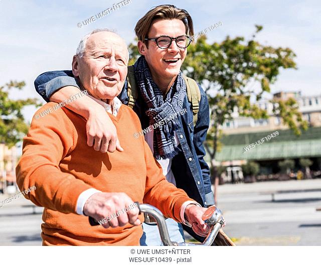 Senior man with adult grandson in the city on the move