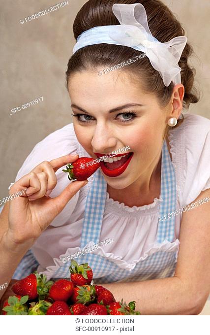 A retro-style girl eating fresh strawberries