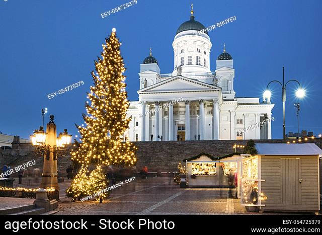 Helsinki, Finland. Christmas Xmas Holiday Carousel On Senate Square Near Famous Landmark. Lutheran Cathedral At Winter Evening