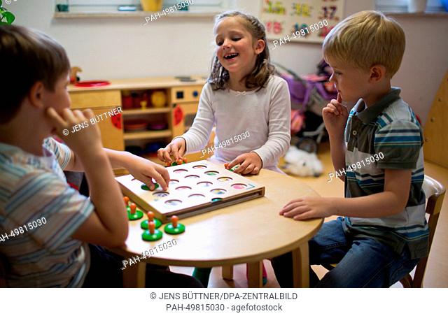 Lukas (L), Magda (M) and Norven (R) play in one of the group rooms of the integrated nursery 'Plappersnut' in Wismar, Germany, 19 June 2014