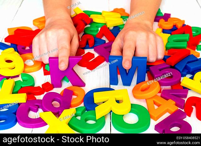 Child learning using magnetic numbers and letters. Education School Concept