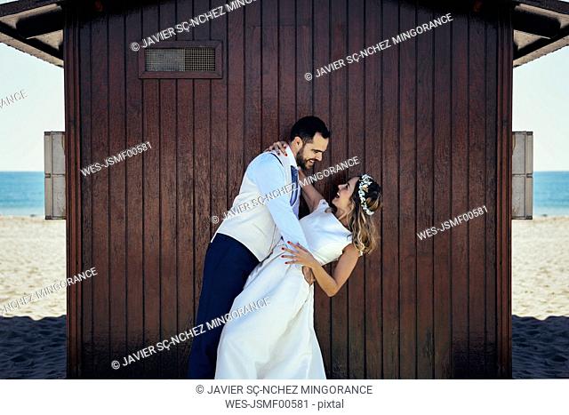 Bridal couple enjoying romantic moments in front of a beach hut