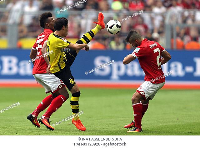 Dortmund's Shinji Kagawa (M) and Mainz's Jean-Philippe Gbamin (l) and Giulio Donati in action in the match of Borussia Dortmund against FSV Mainz 05 on the...