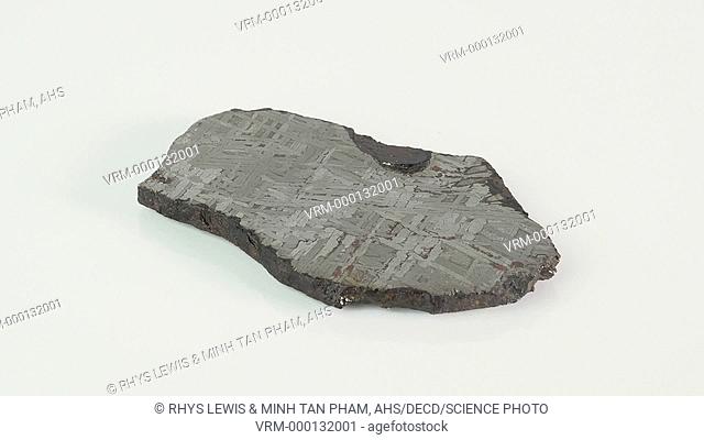 Toluca meteorite fragment. This is a section through the meteorite showing a Widmanstatten pattern. This distinctive criss-cross pattern is found in iron-nickel...