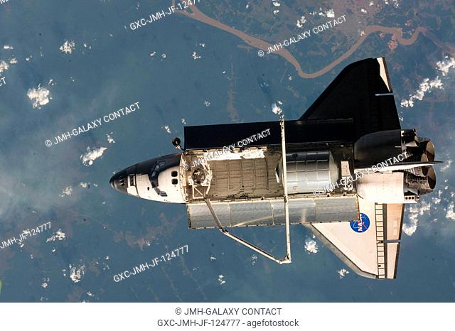 Backdropped by a colorful part of Earth, Space Shuttle Discovery (STS-128) is featured in this image photographed by an Expedition 20 crew member on the...