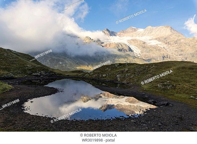 Piz Arlas, Cambrena, Caral reflected in water, Bernina Pass, Poschiavo Valley, Engadine, Canton of Graubunden, Switzerland, Europe