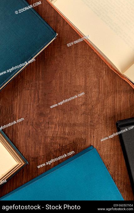 An overhead photo of old books, shot from above on a dark background with a place for text