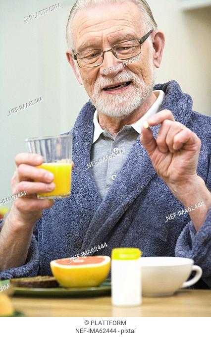 An elderly man having his medicine Sweden