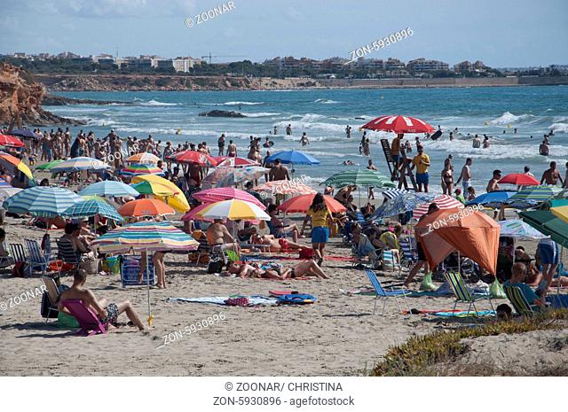 LA ZENIA, ORIHUELA, COSTA BLANCA, SPAIN ON JULY 29 2012: Beach crowded with sun-loving holidaymakers on July 29, 2012 in La Zenia, Spain
