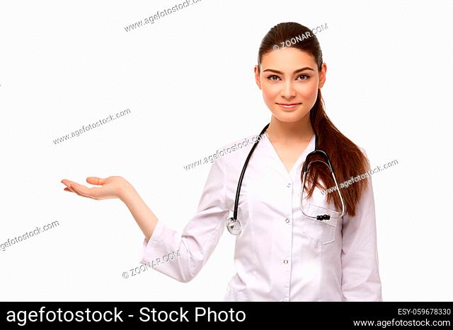 beautiful woman doctor with stethoscope in medical robe showing something isolated on white background. copy space
