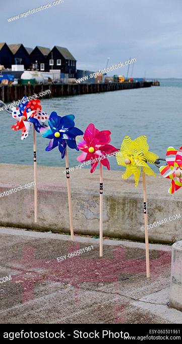 28 October 2020 - England: Children's decorative toy windmills by sea. High quality photo