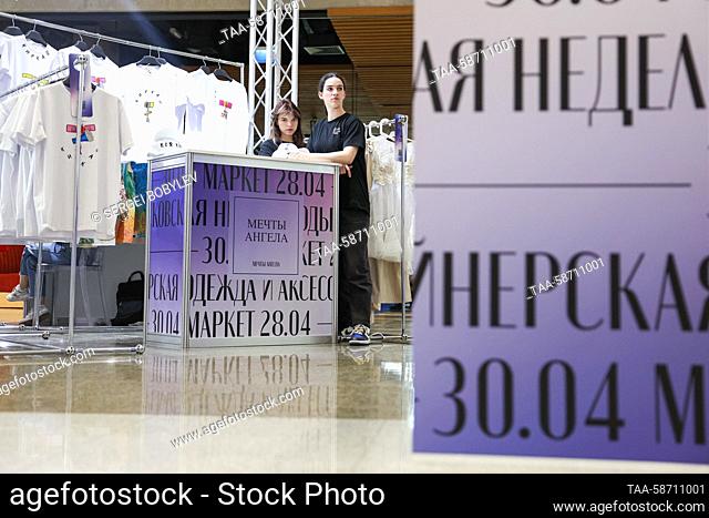 RUSSIA, MOSCOW - APRIL 28, 2023: Staff members are seen amid clothing racks during the Moscow Fashion Week at the Oceania Shopping Centre