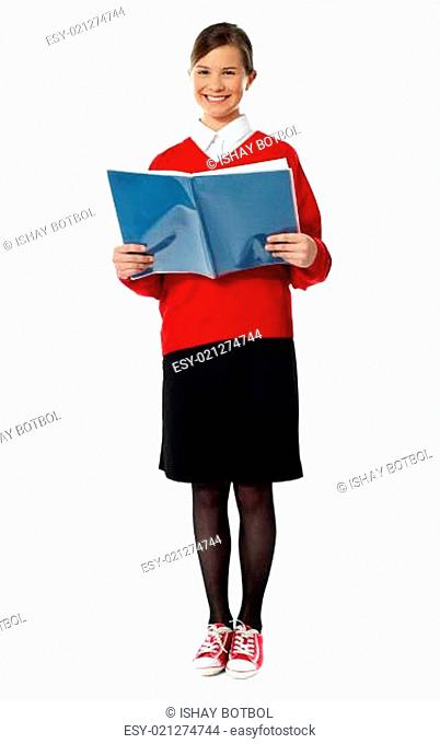 Smiling girl standing with exercise book