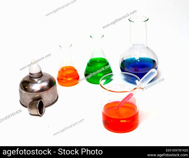 Group of laboratory flasks empty or filled with a clear liquid on white background