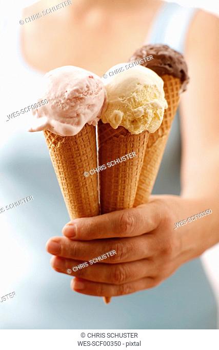 Woman holding ice cream, upper section, close-up