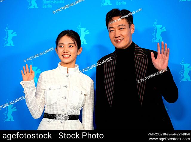 18 February 2023, Berlin: Actors Huang Yao (l) and Xin Baiqing (r) stand next to each other and wave during the photocall for director Zhang Lu's film ""The...