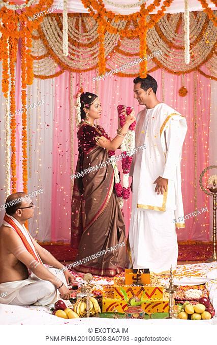 Bride putting garland to a bridegroom during the South Indian wedding ceremony
