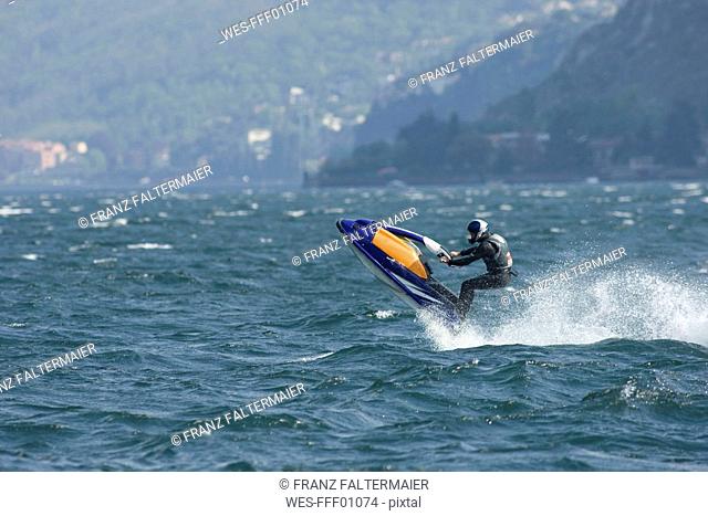 Italy, Lake Como, Man riding speedboat