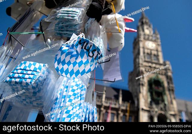 06 May 2020, Bavaria, Munich: A souvenir stand on Marienplatz offers face masks with the Bavarian diamond flag. In the background you can see the town hall
