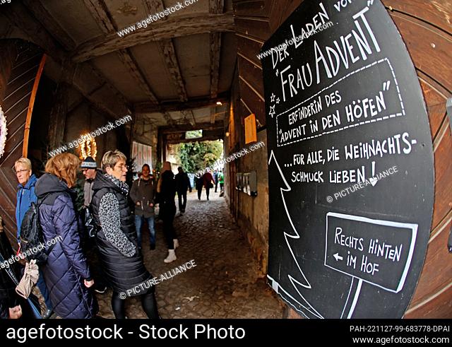 27 November 2022, Saxony-Anhalt, Quedlinburg: A sign advertising a business hangs at the entrance to a courtyard. Quedlinburg once again attracted thousands of...