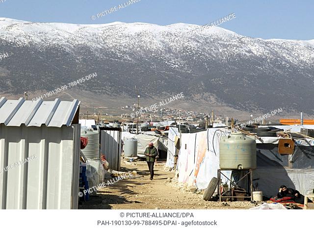 30 January 2019, Lebanon, Al Marj: A Syrian refugee man walks between the tents of Al Marj refugee camp. Lebanon, host of some 1