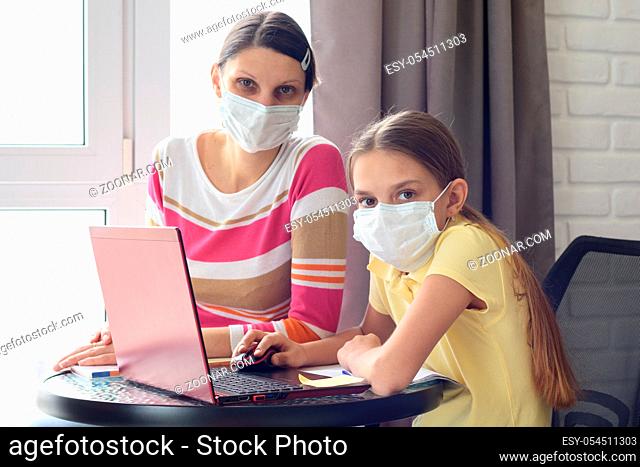 The quarantined family in the isolation ward, mom and daughter doing homework, looked into the frame