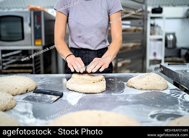 Close-up of woman preparing bread in bakery