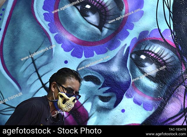 MEXICO CITY, MEXICO - OCTOBER 30: Urban artist Roberto Islas , with more than 20 years of experience in this job, paints a Day of the dead graffiti
