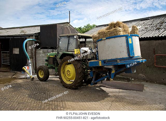 John Deere 2450 tractor with straw bedding machine on dairy farm, Preston, Lancashire, England, July