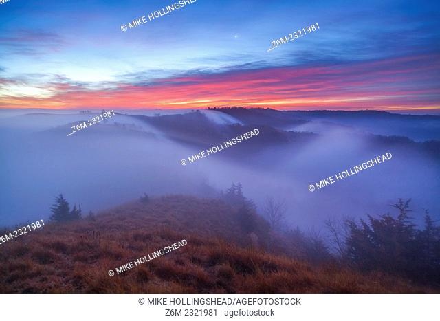 Moonlit fog flows in the valleys around the Loess Hills in western Iowa at sunrise