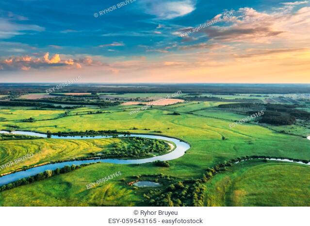 Aerial View. Sunny Sky Above Green Forest, Meadow And River Landscape In Sunny Evening. Top View Of European Nature From High Attitude In Summer Sunrise