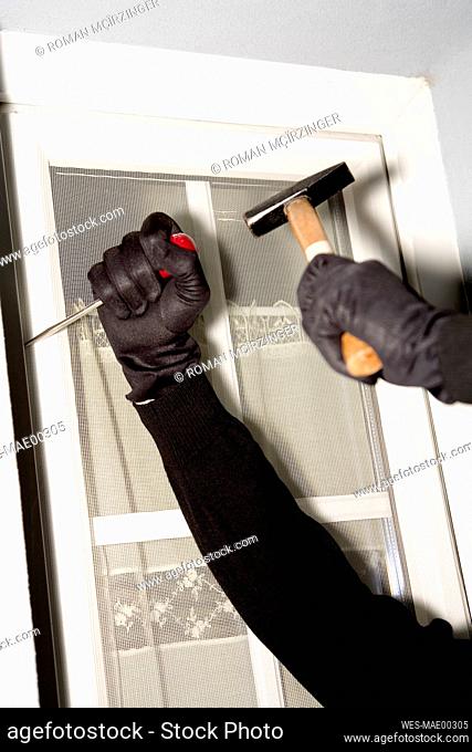 Burglary, hand with gloves on window, close-up