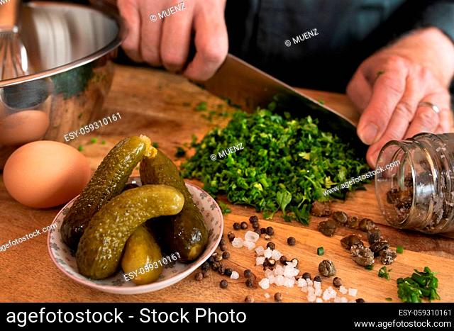 Preparing a gribiche sauce for green asparagus. Hands prepare fresh ingredients for a tasty side dish. Gastronomy and lifestyle background