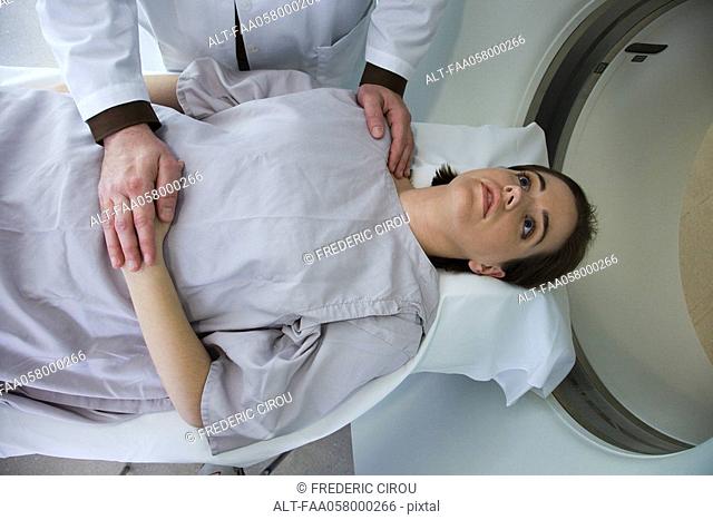 Doctor reassuring female patient preparing to undergo CAT scan