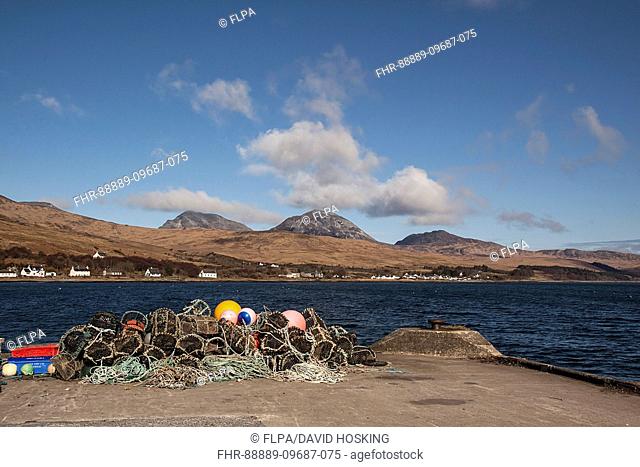 Lobster pots on Jura Pier with the village of Craighouse and the Paps of Jura