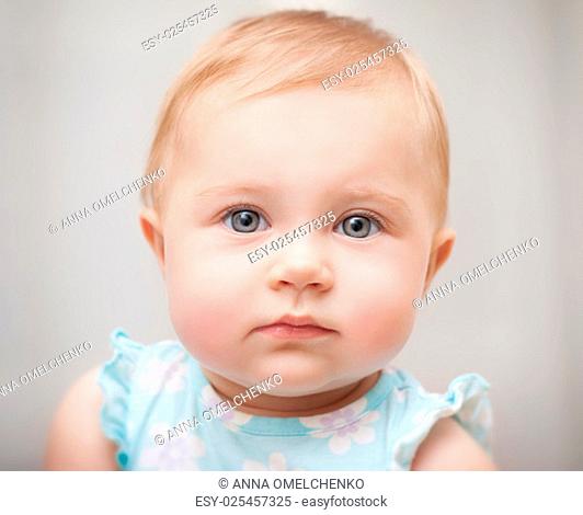 Closeup portrait of a beautiful little baby girl isolated on gray background, carefree childhood, precious innocent kid