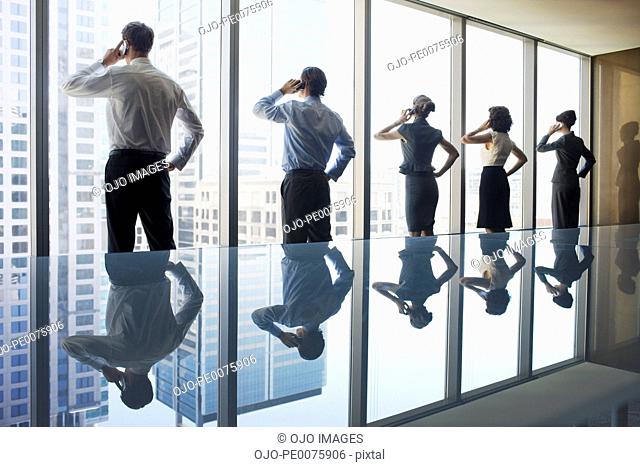 Business people using cell phones in conference room